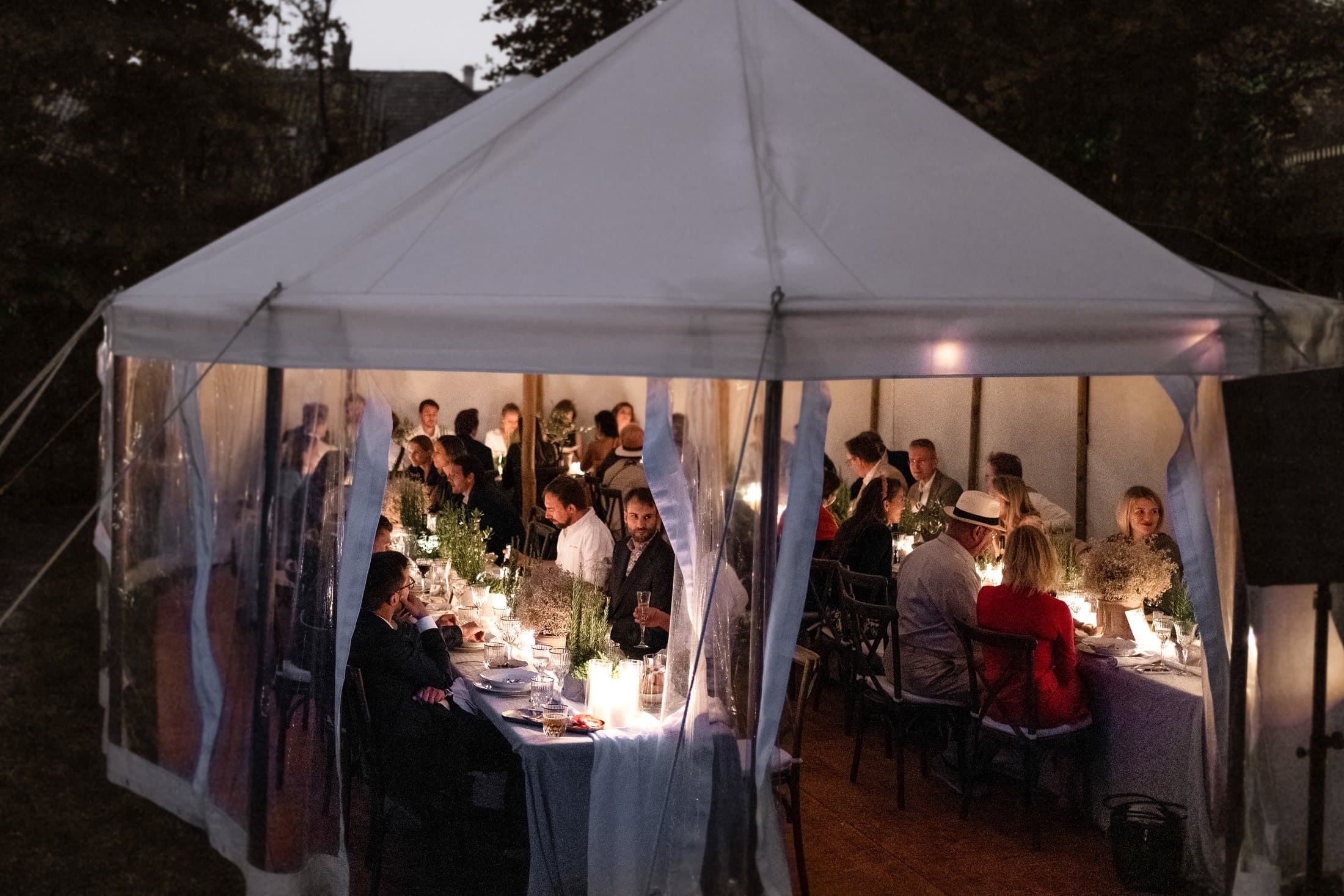 Beleuchtetes Stoffzelt am Abend mit Hochzeitsgesellschaft am Comersee